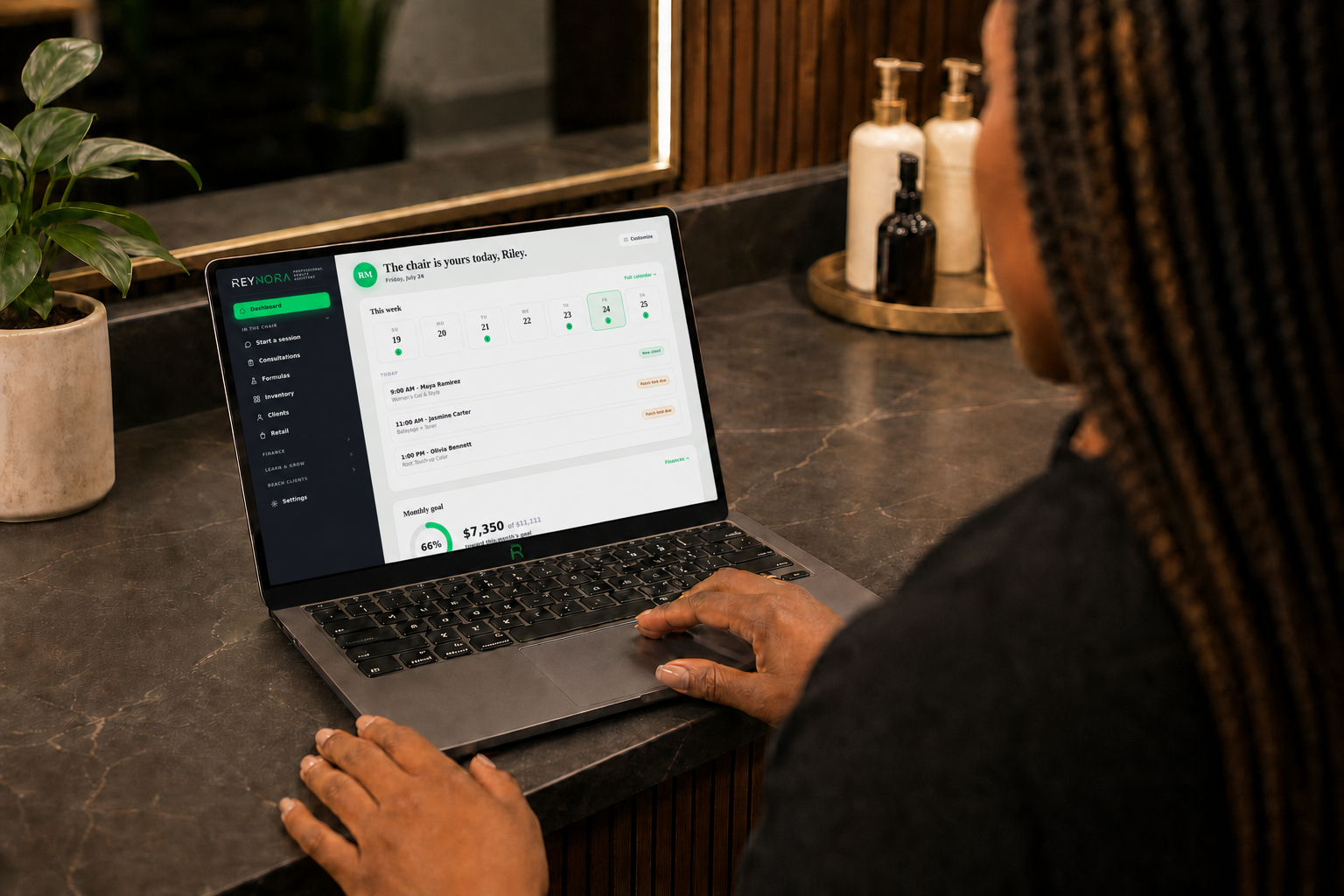 Braided hairstylist reviewing the Reynora business dashboard
